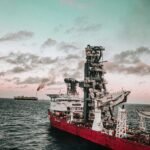 red and white ship on sea under cloudy sky during daytime